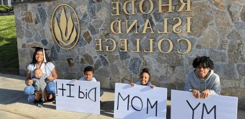Three kids holding up a "my mom did it!" sign with a women and a baby.